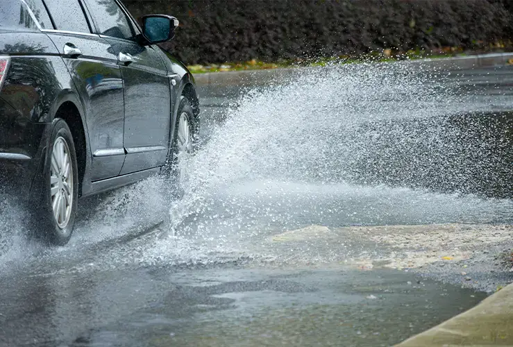 Car driving through water on the road