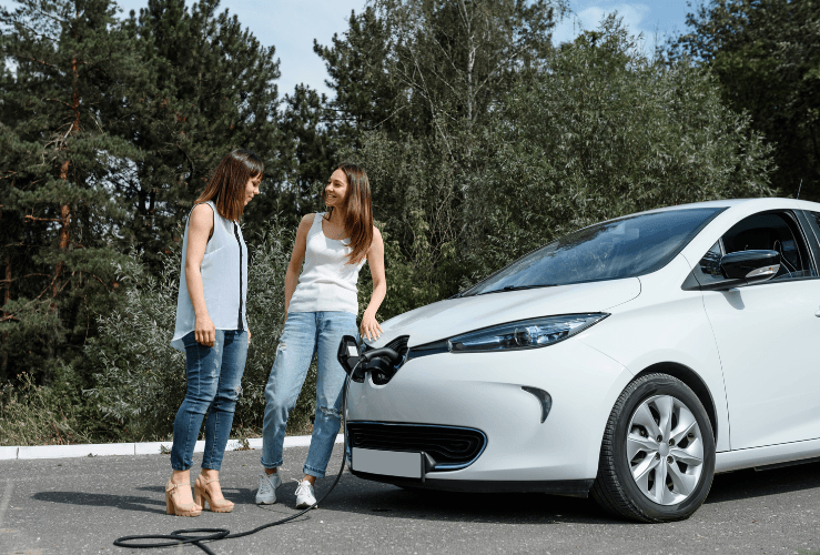 Women chatting whilst charging EV