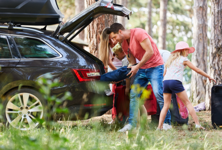 Family packing car boot ahead of long drive
