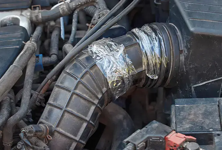 An air intake hose temporarily repaired with duct tape 
