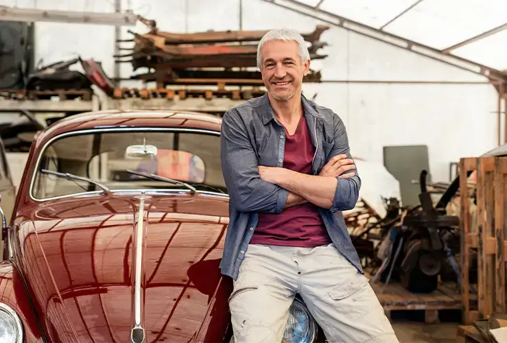 A man standing in front of his classic car