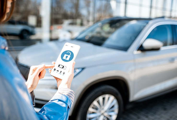 Woman unlocking car using mobile application on smartphone