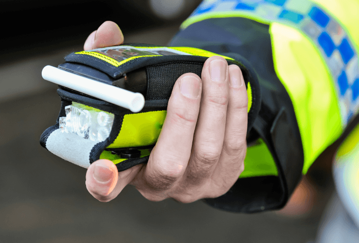 Police with hand held breathalyser for drink driving