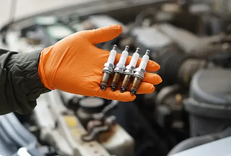 A hand holding spark plugs