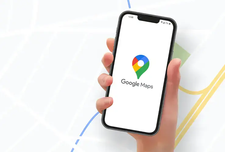 A person holding a phone displaying the Google Maps logo