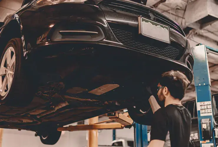 Mechanic looking under a lifted car