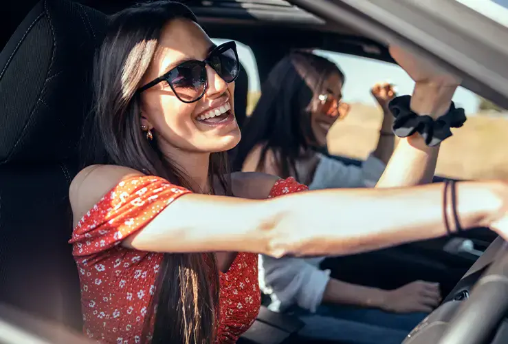 Two women singing in a car