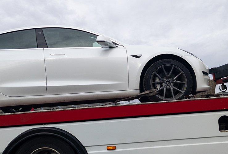 Electric Vehicle on a flatbed truck after breaking down 