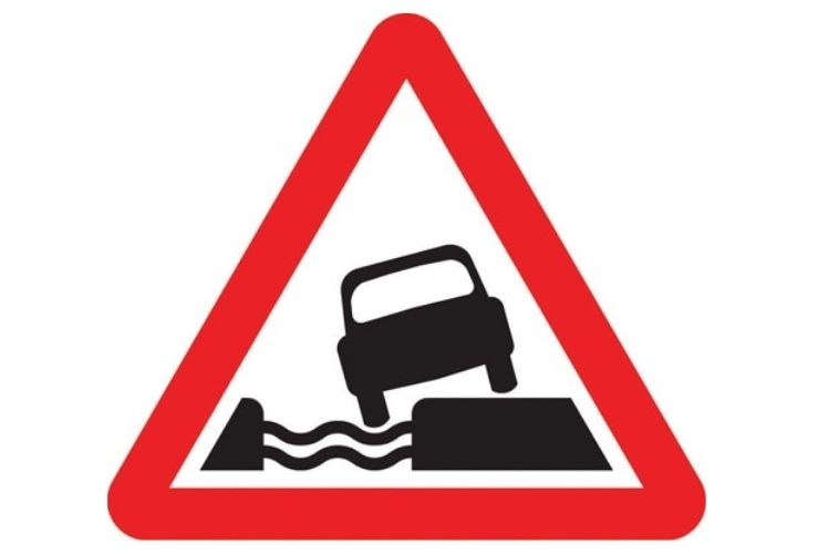 Water course alongside road road sign