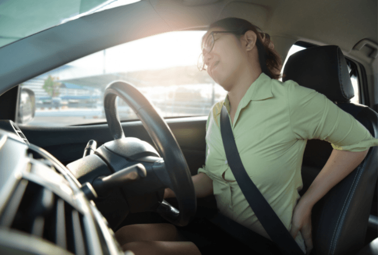 Woman suffering back pain when driving