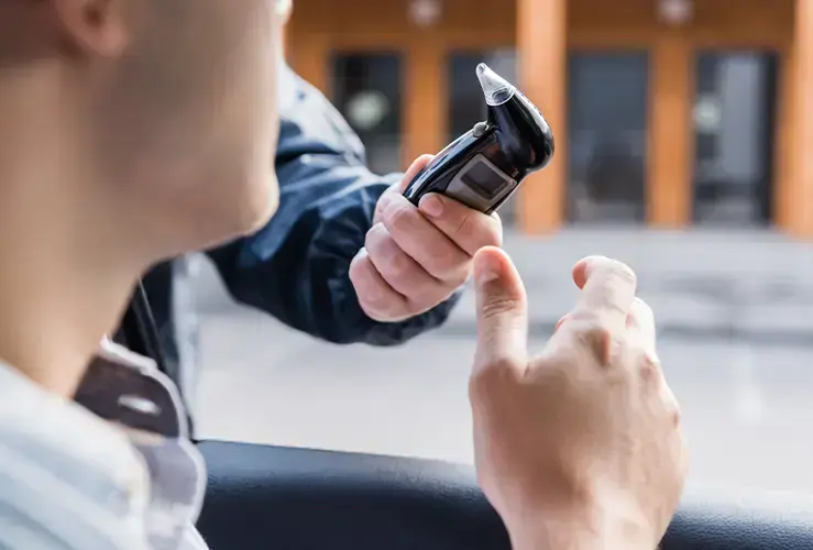 A driver taking a breathalyser test