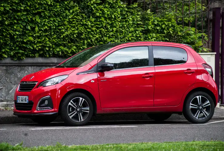 Red Peugeot 108 parked in the street