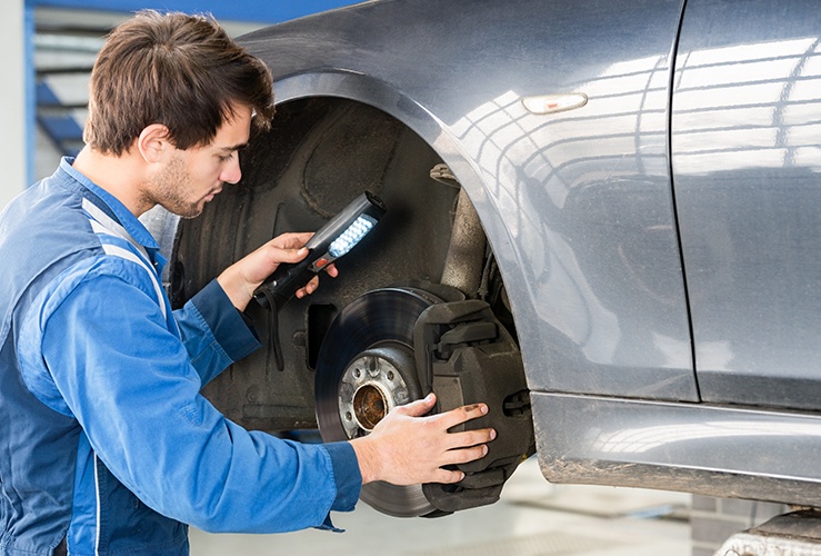 Mechanic examining brake disc on a car