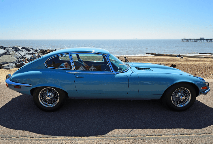 Classic blue Jaguar E Type, parked on seafront