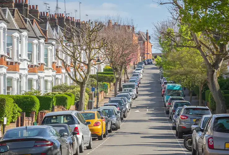 Cars parked outside houses down a street