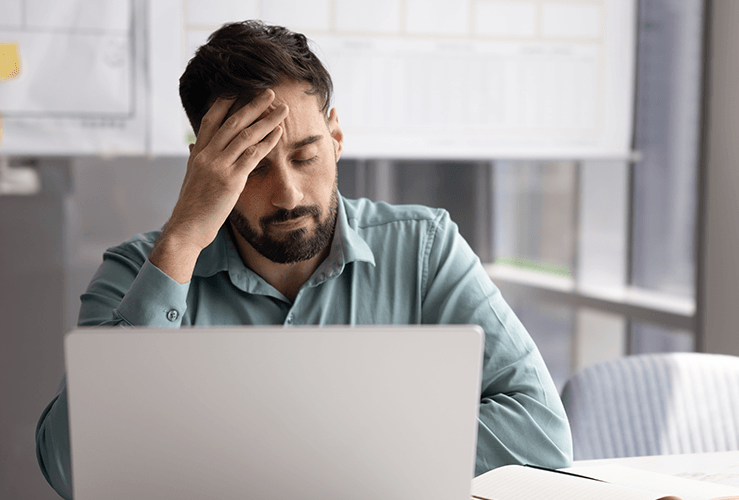 A man looking worried at his laptop