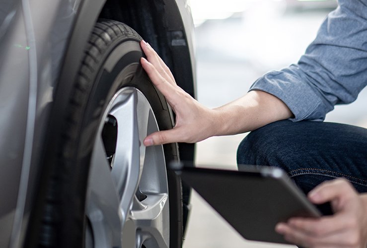 man checking tyres with tablet