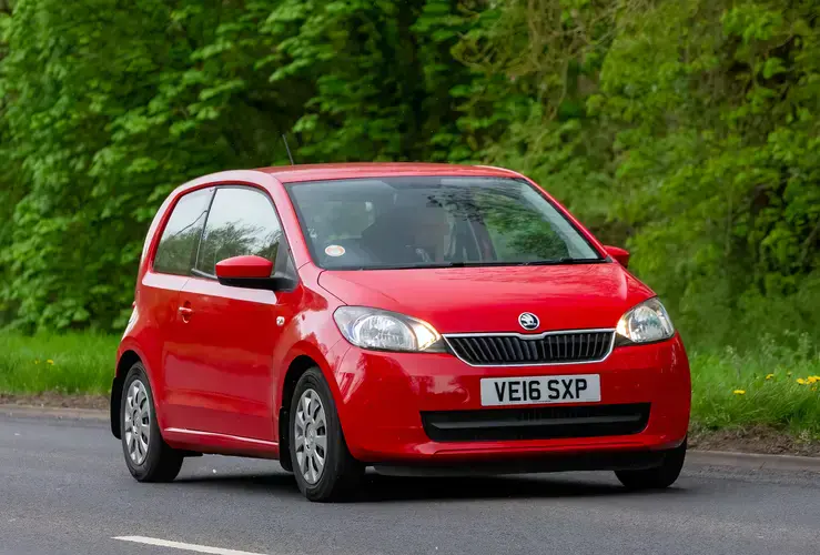 Red Skoda Citigo driving on British country road