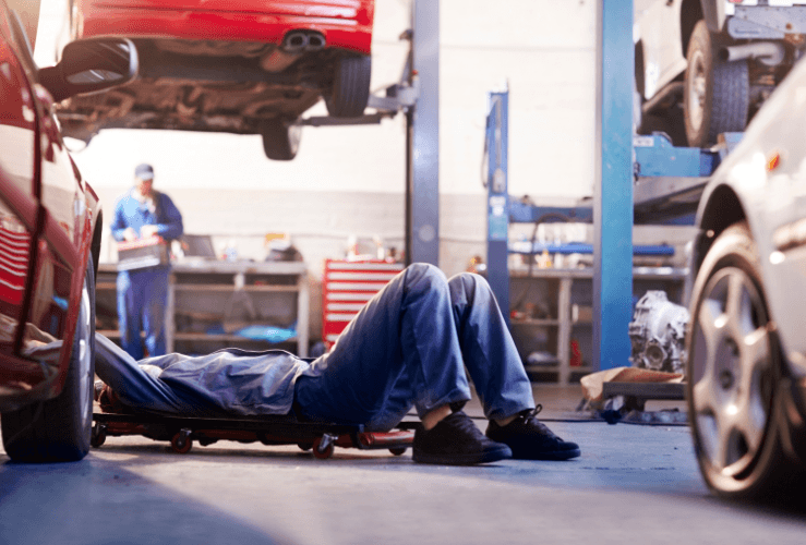 Mechanic at garage fixing old car